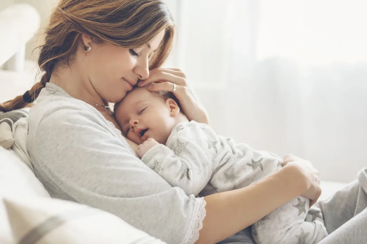 Mother gently cradling her newborn baby